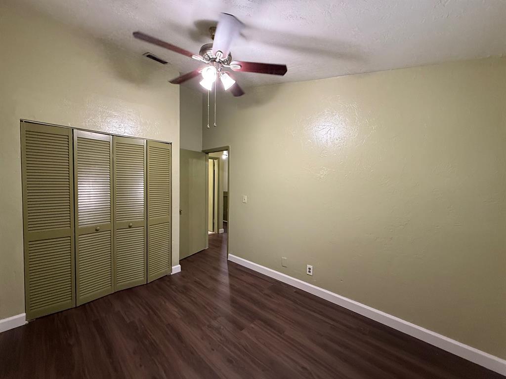 11571 Northwest 35th Street, Unit 11571 Coral Springs, FL 33065 - Photo 19 of 29 an empty room with wooden floor fan and windows
