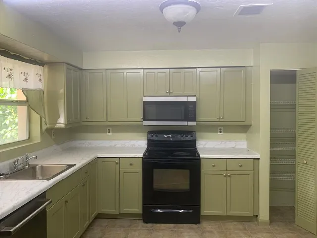 a kitchen with a sink stove and microwave
