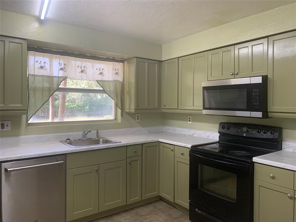 11571 Northwest 35th Street, Unit 11571 Coral Springs, FL 33065 - Photo 9 of 29 a kitchen with a sink stove and microwave