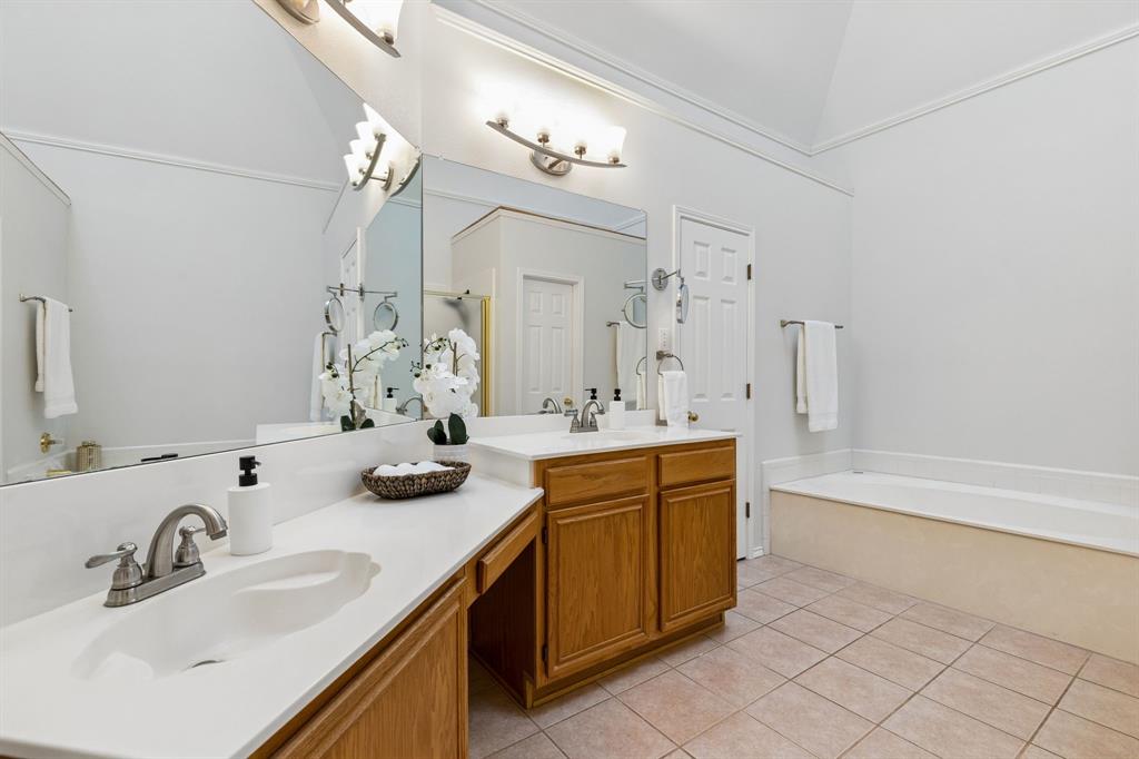 915 Rutgers Court Allen, TX 75002 - Photo 22 of 39 The large primary bath offers dual vanities, separate water closet and a large jetted tub. The door shown here leads to the spacious walk in closet.