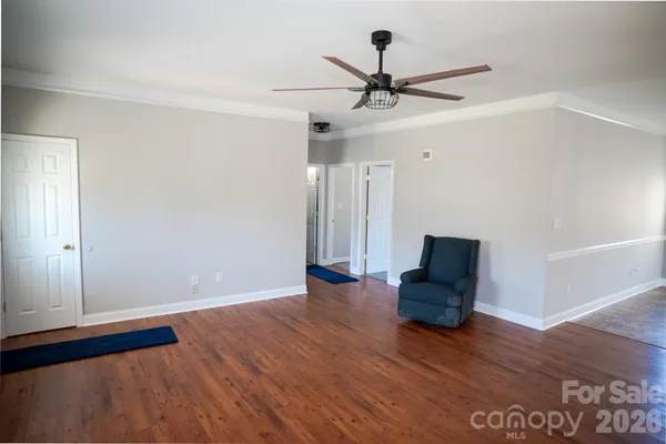 a view of room with wooden floor and ceiling fan