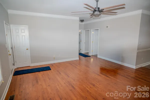 a view of room with wooden floor and ceiling fan