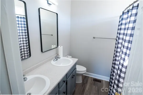 a bathroom with a sink a toilet a mirror and shower
