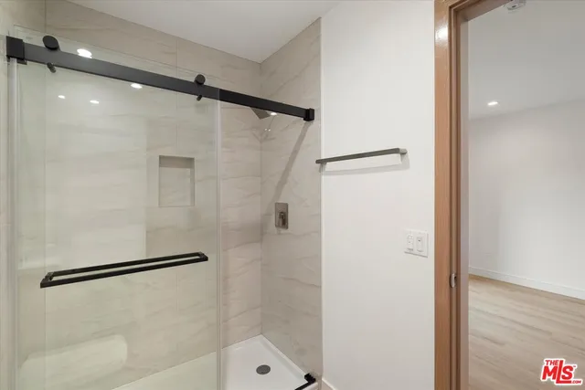 a bathroom with a shower and a glass door