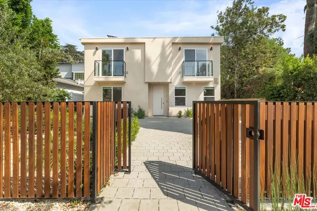 a view of a house with wooden fence