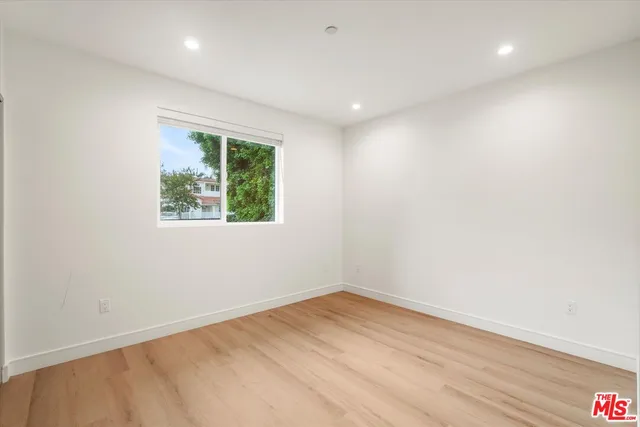 an empty room with wooden floor and window