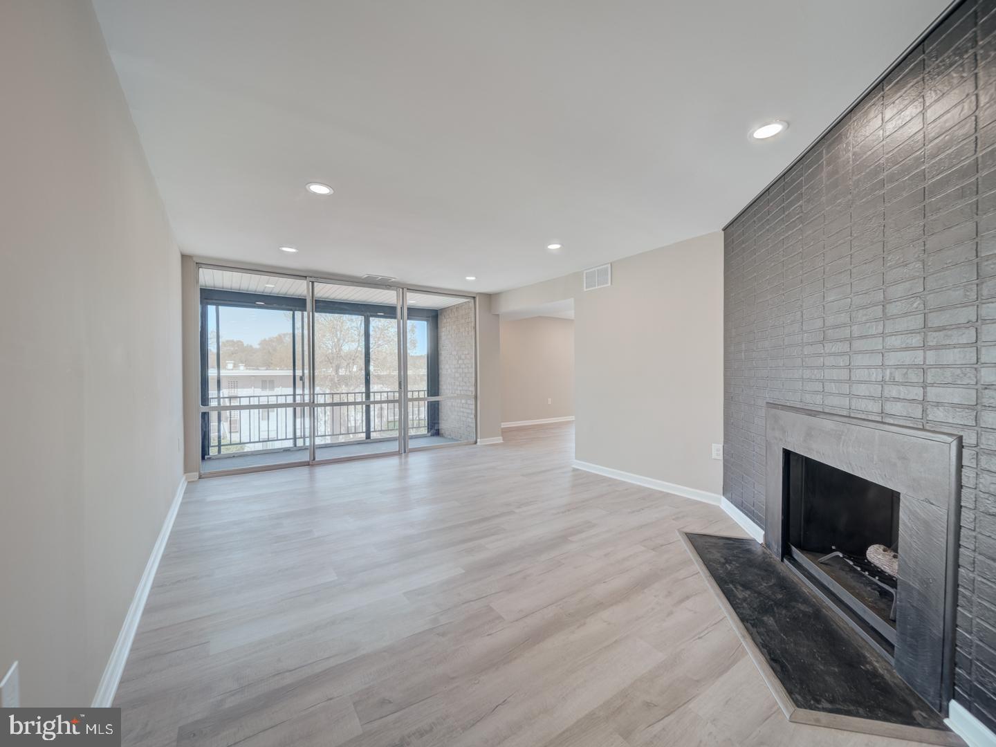 8675 Greenbelt Road, Unit 202 Greenbelt, MD 20770 - Photo 11 of 47 a view of an empty room with a fireplace and a window