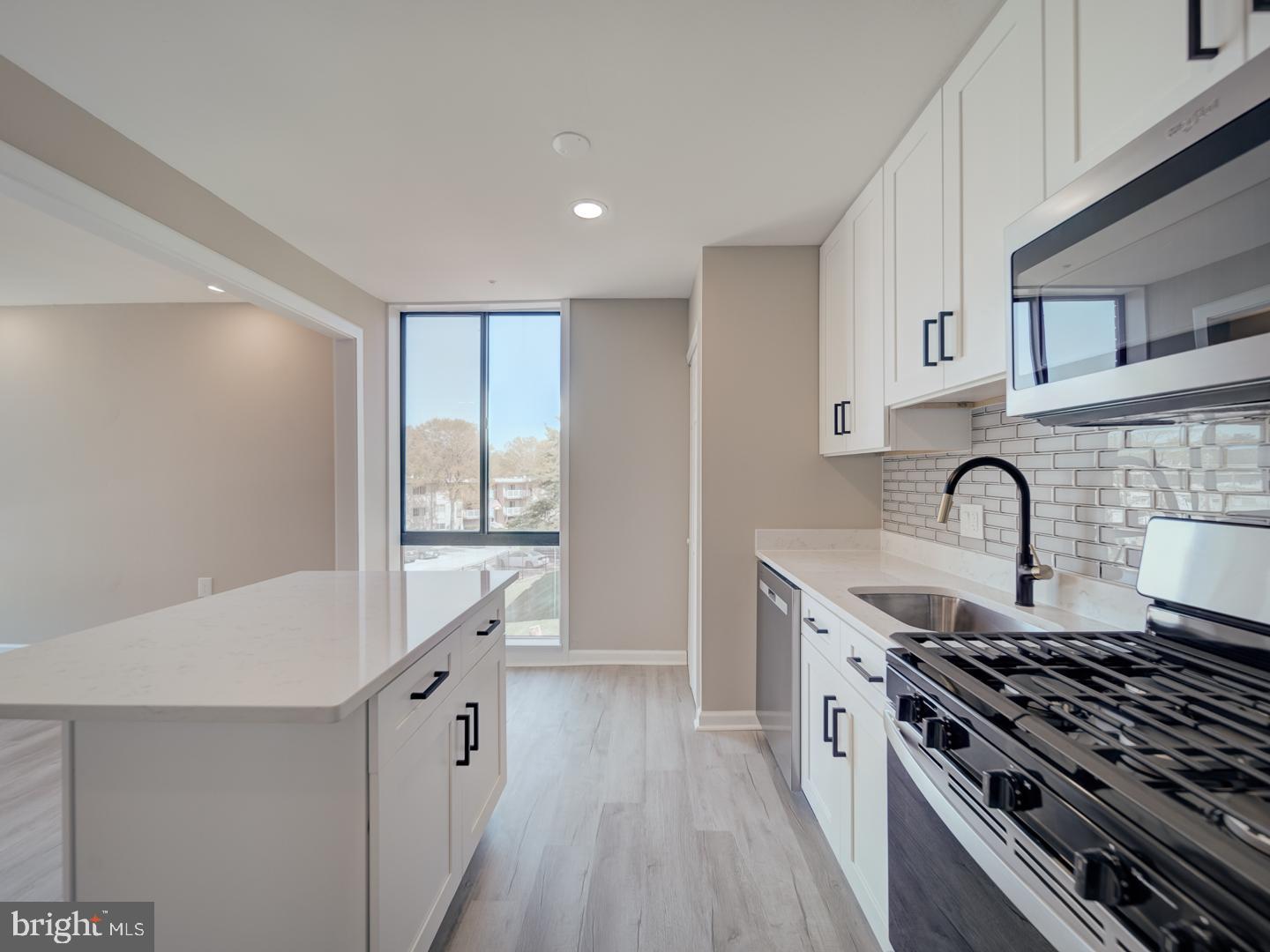8675 Greenbelt Road, Unit 202 Greenbelt, MD 20770 - Photo 23 of 47 a kitchen with granite countertop a stove and a sink