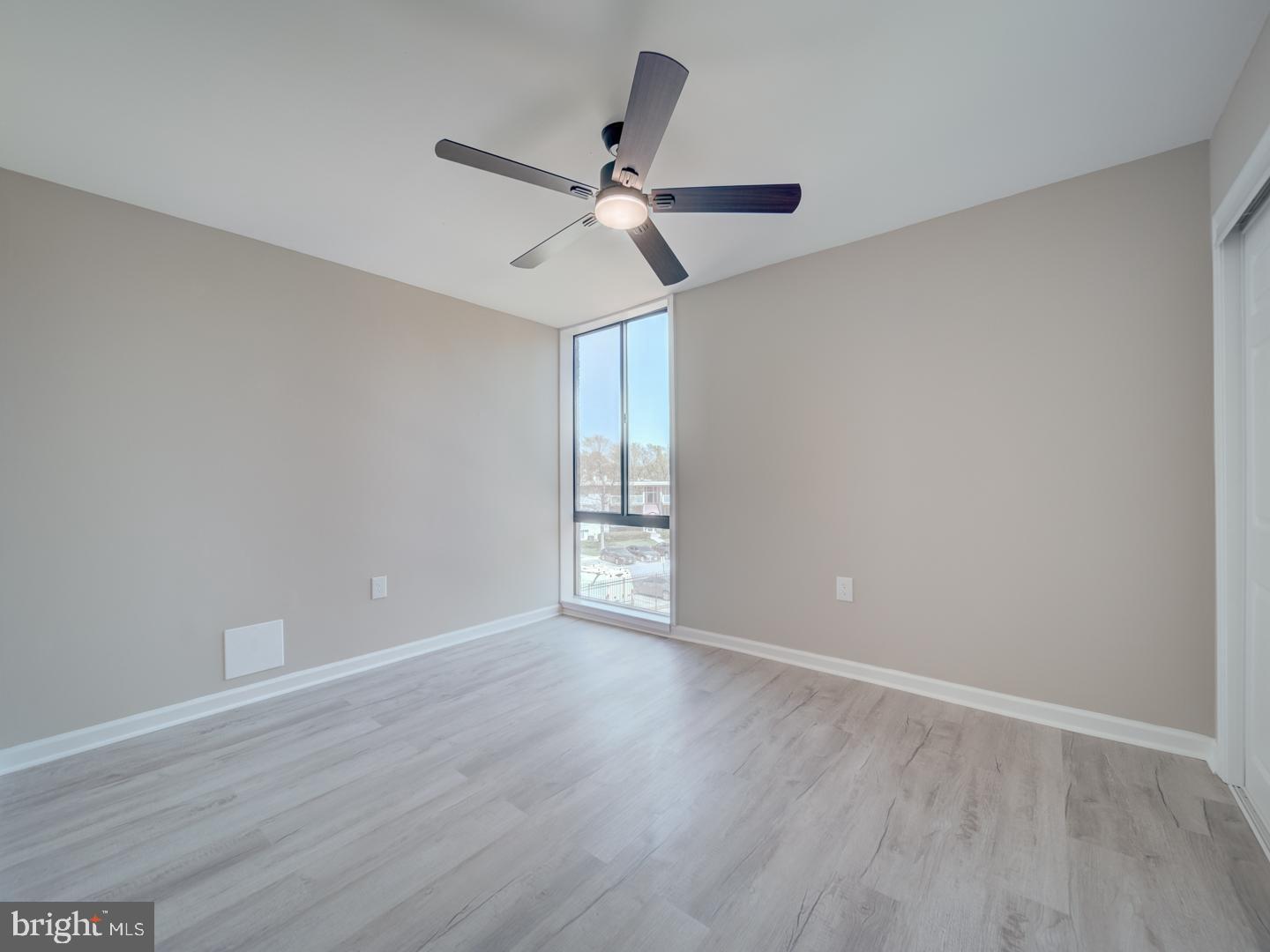 8675 Greenbelt Road, Unit 202 Greenbelt, MD 20770 - Photo 29 of 47 a view of an empty room with wooden floor and a ceiling fan