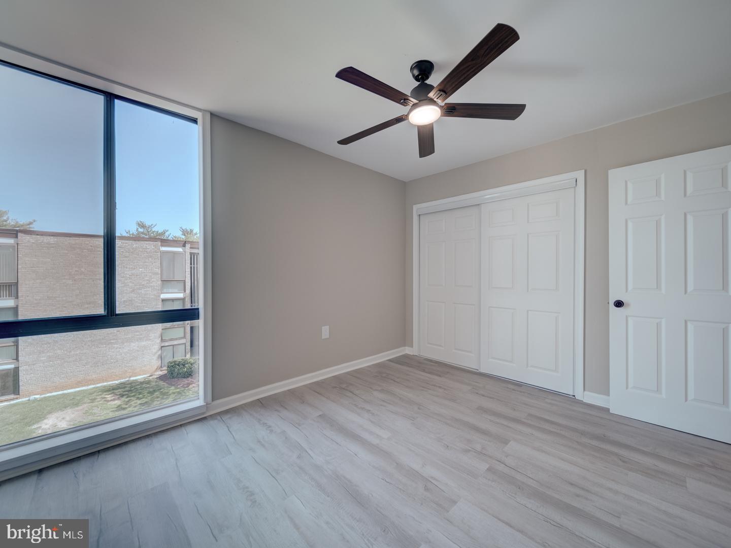 8675 Greenbelt Road, Unit 202 Greenbelt, MD 20770 - Photo 30 of 47 an empty room with wooden floor fan and windows
