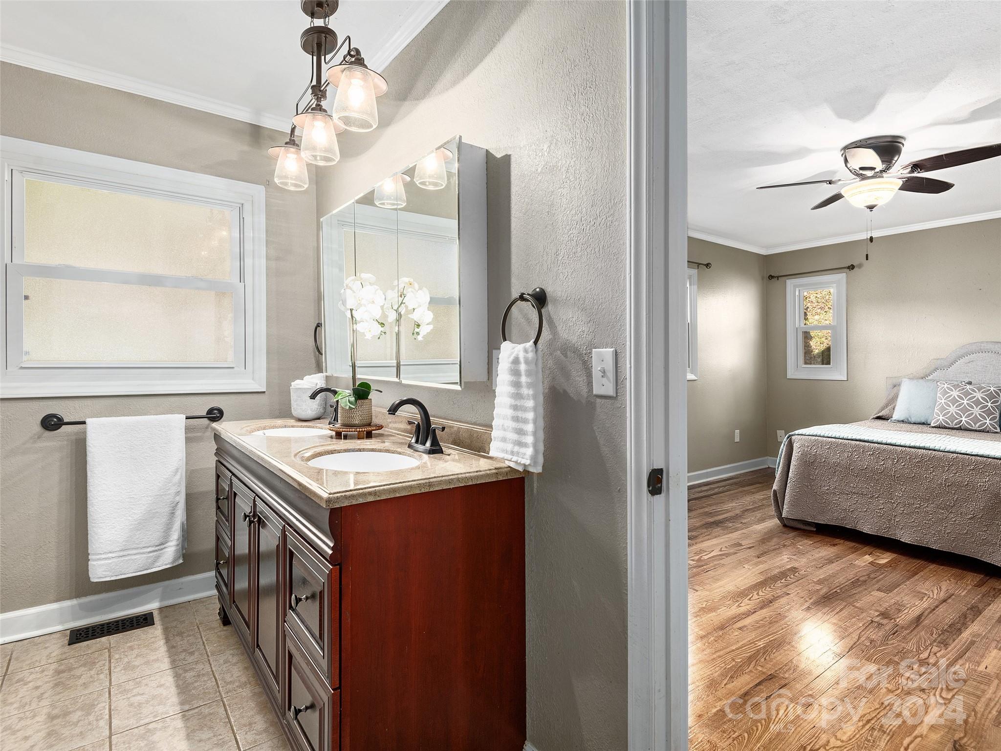 251 Jade Drive Clyde, NC 28721 - Photo 13 of 40 a bathroom with a granite countertop sink a mirror and a shower