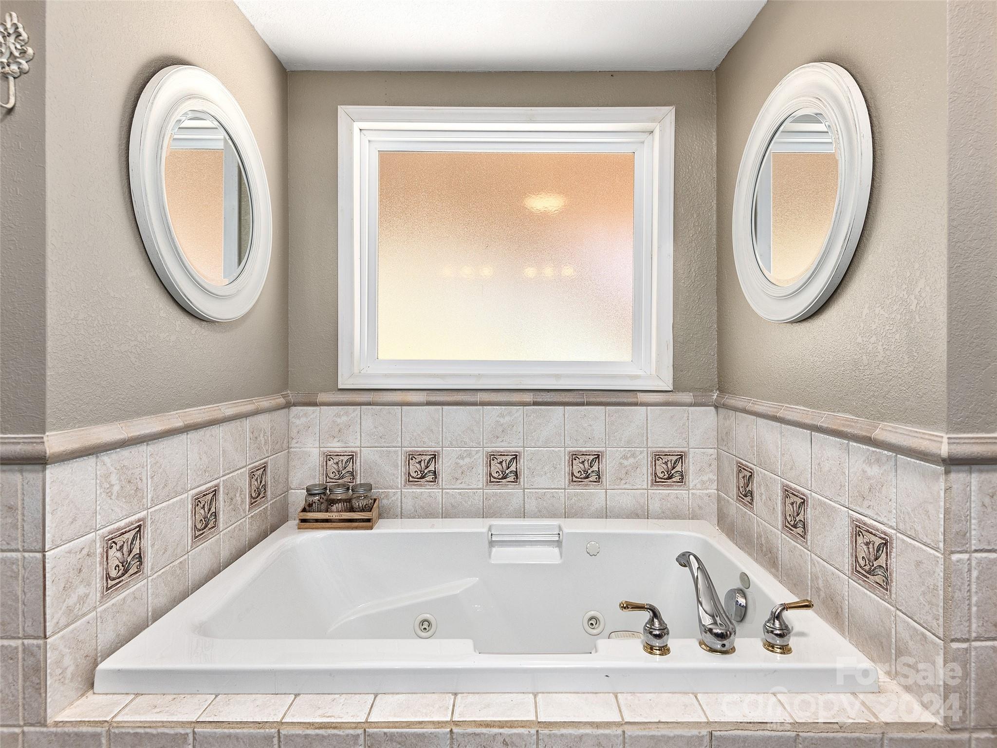 251 Jade Drive Clyde, NC 28721 - Photo 25 of 40 a bathroom with a bathtub and a window