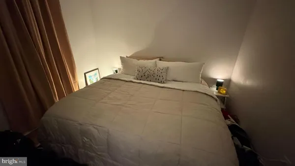 a large bed sitting in a bedroom next to a window