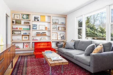 a living room with furniture and a book shelf