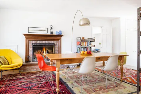 a living room with patio chairs and a fireplace