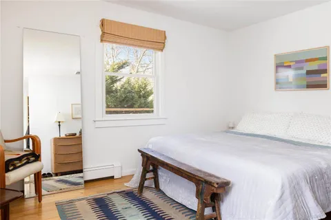 a bedroom with a bed and a dresser next to a window