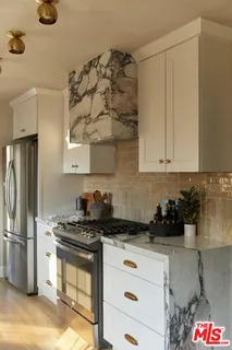 a kitchen with stove a sink and cabinets