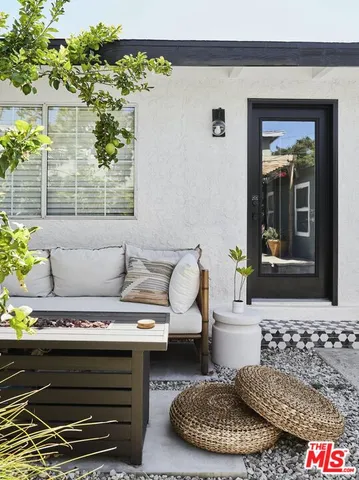 a roof deck with table and chairs and potted plants