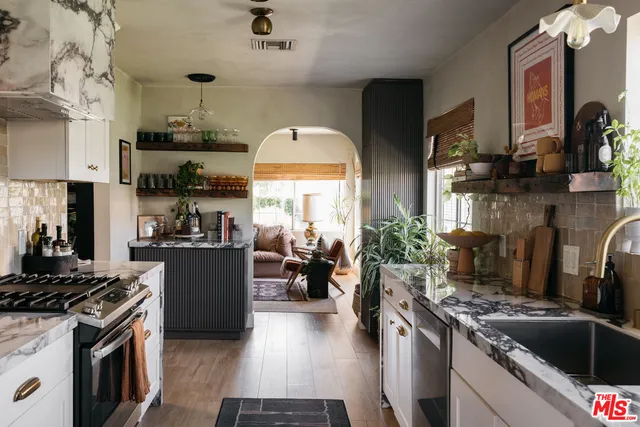 a kitchen with stainless steel appliances granite countertop a stove a sink dishwasher and cabinets with wooden floor