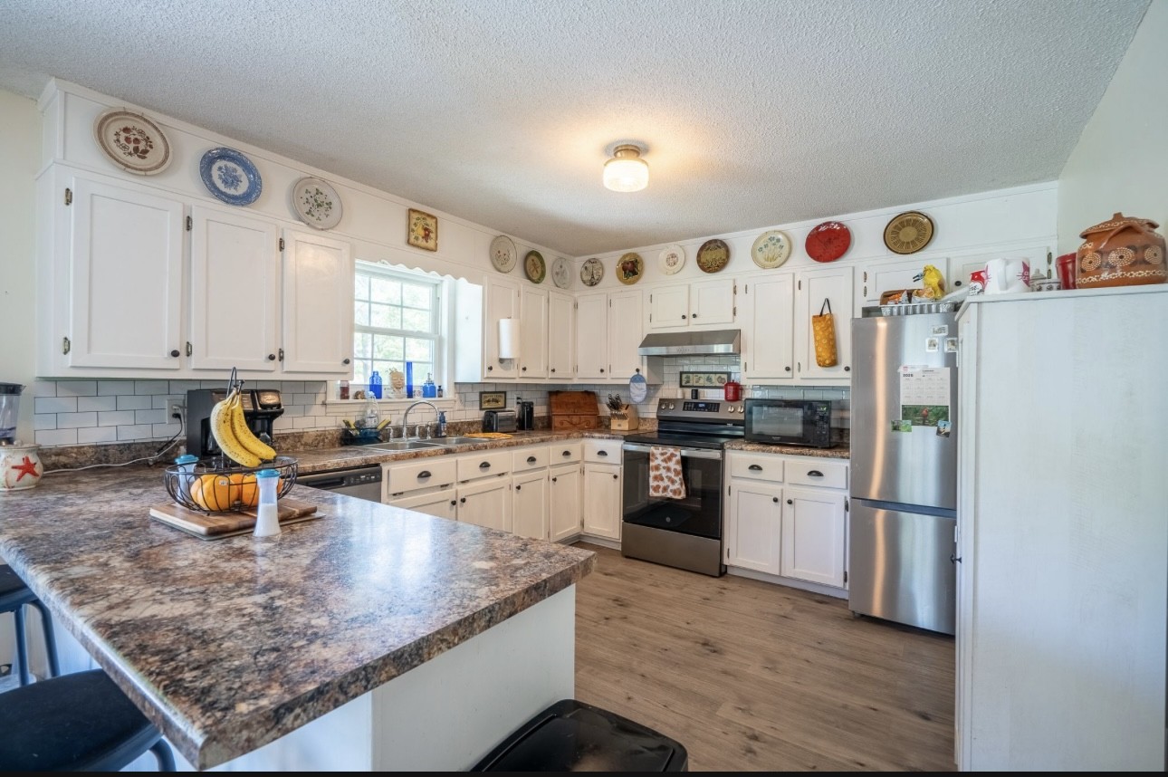 652 Old Florence Pulaski Road Leoma, TN 38468 - Photo 8 of 20 a kitchen with stainless steel appliances granite countertop a sink stove and refrigerator