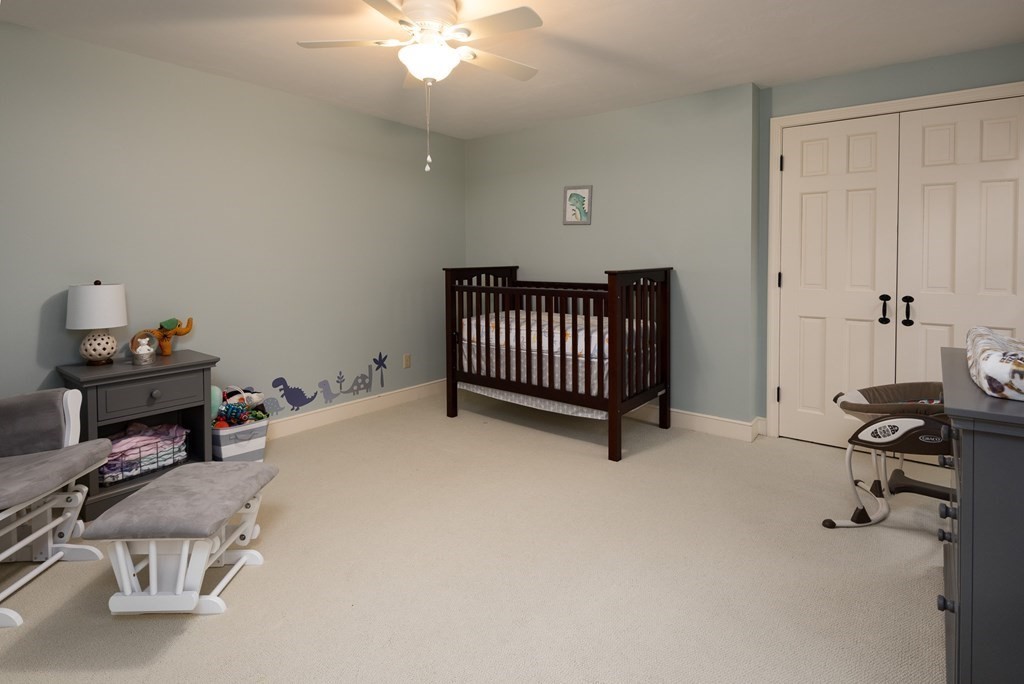 170 Saddle Hill Road Hopkinton, MA 01748 - Photo 26 of 31 a bedroom with a bed and a chandelier