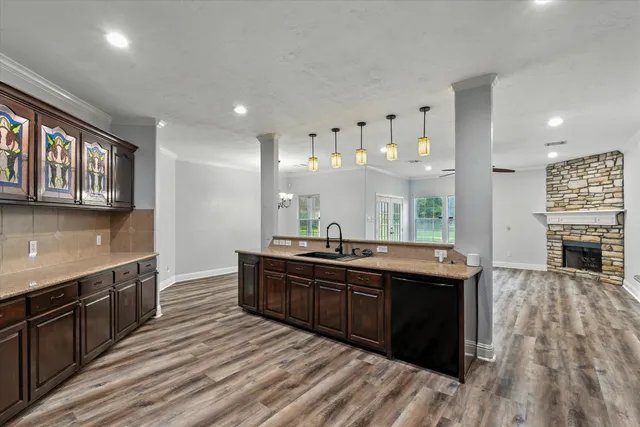 a kitchen with stainless steel appliances granite countertop a sink stove and wooden cabinets