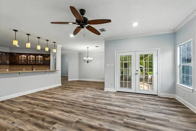 a view of an empty room with window and wooden floor