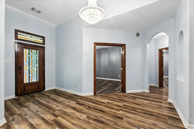 a view of a livingroom with wooden floor and a chandelier
