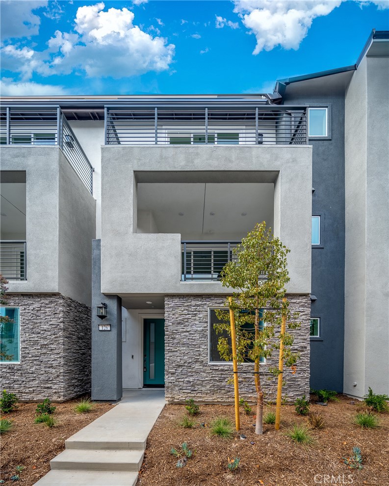 a front view of a house with plants