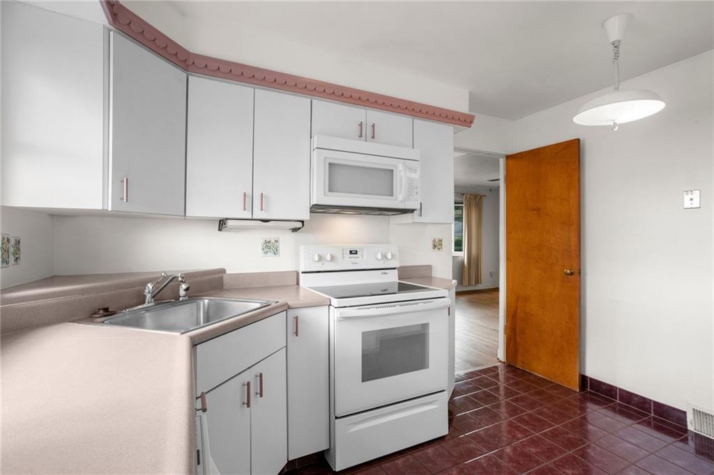3323 Shady Ave Extension Pittsburgh, PA 15217 - Photo 16 of 45 a kitchen with stainless steel appliances granite countertop a sink a stove a refrigerator and cabinets