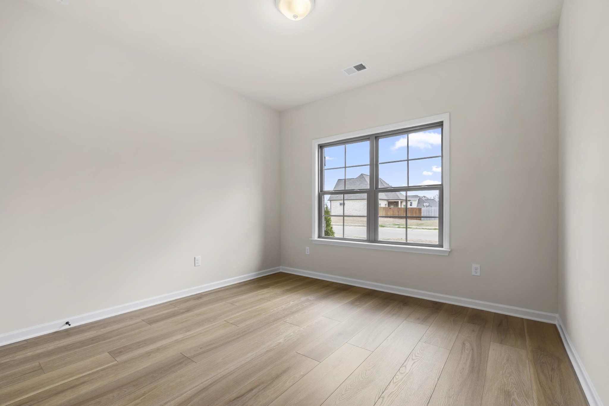 180 Oakland Rdg Cove Oakland, TN 38060 - Photo 18 of 27 an empty room with wooden floor and windows