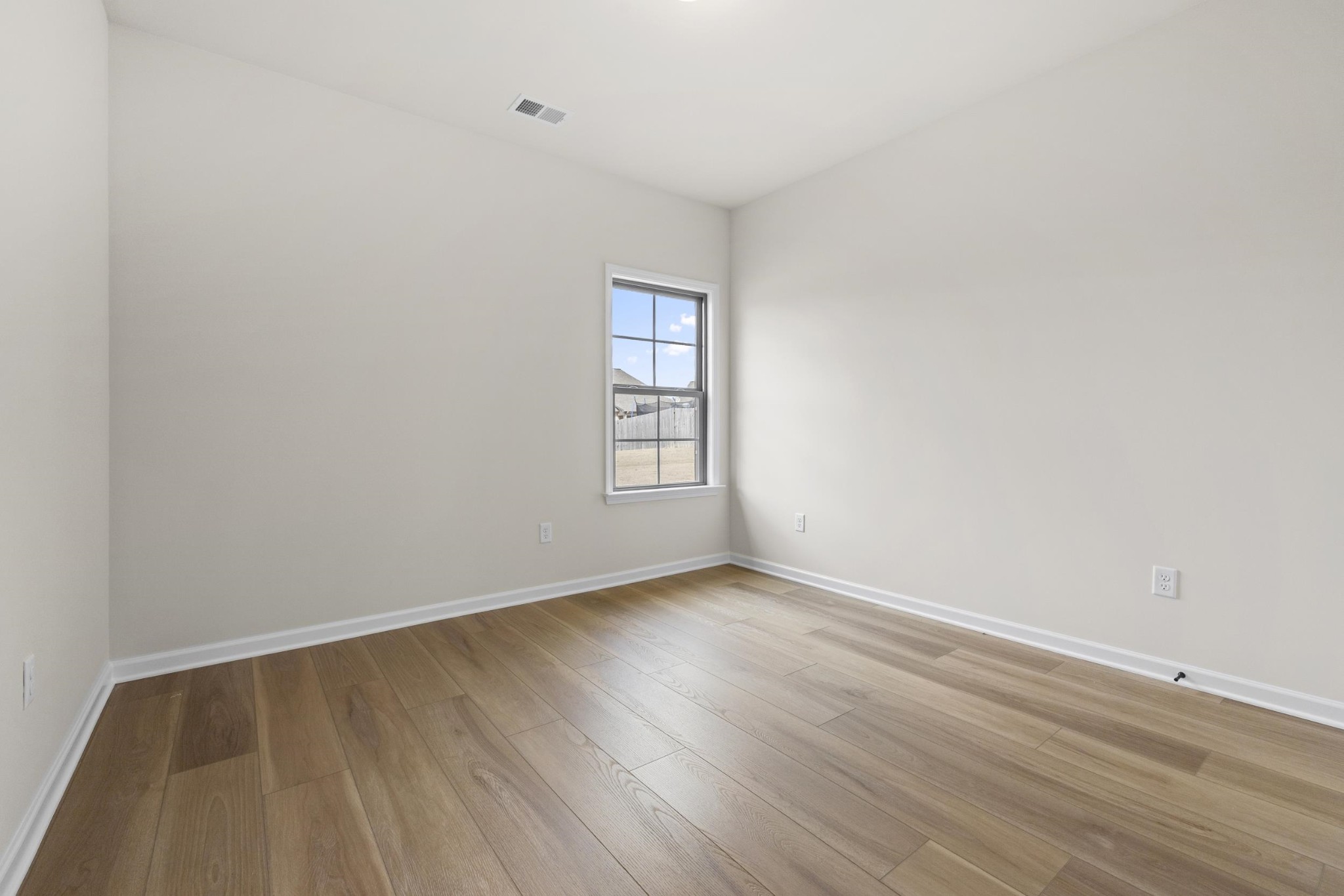 180 Oakland Rdg Cove Oakland, TN 38060 - Photo 20 of 27 an empty room with wooden floor and windows