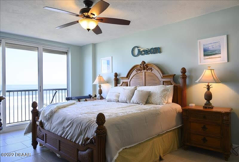 4555 South Atlantic Avenue, Unit 4207 Ponce Inlet, FL 32127 - Photo 16 of 33 a bedroom with a bed and a chandelier