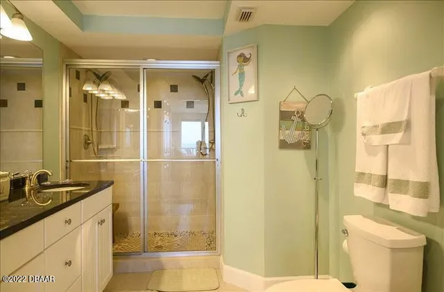 a bathroom with a granite countertop sink a toilet and shower