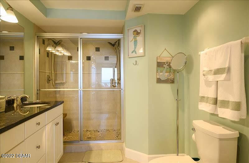 4555 South Atlantic Avenue, Unit 4207 Ponce Inlet, FL 32127 - Photo 19 of 33 a bathroom with a granite countertop sink a toilet and shower
