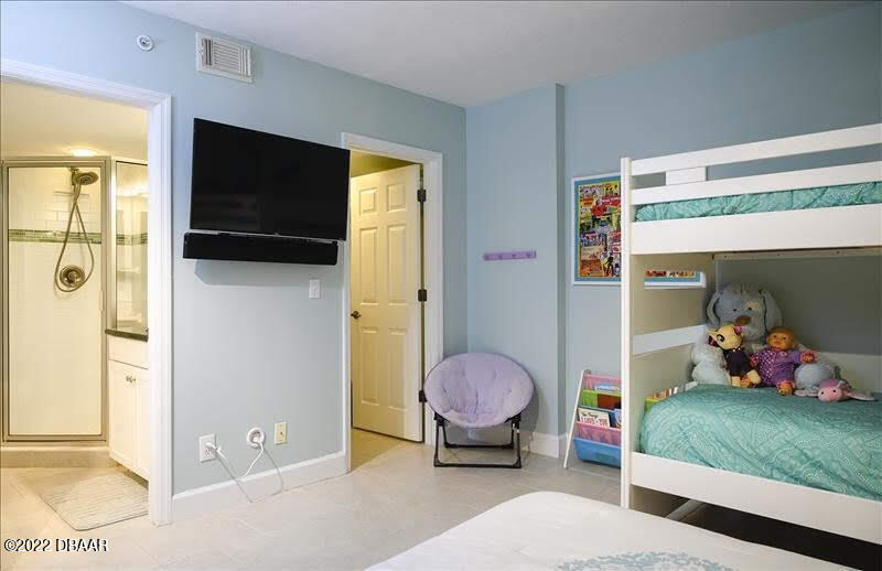 4555 South Atlantic Avenue, Unit 4207 Ponce Inlet, FL 32127 - Photo 21 of 33 a living room with a bed furniture and a flat screen tv