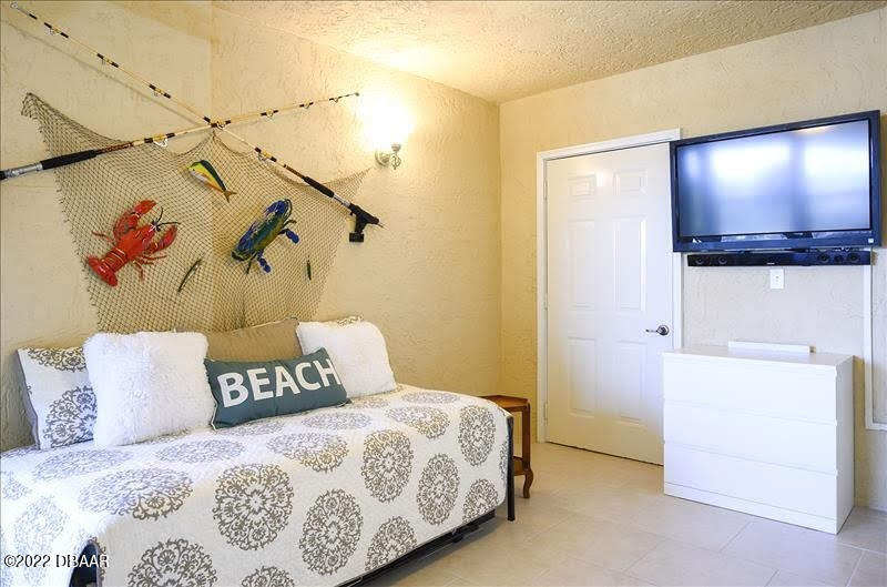 4555 South Atlantic Avenue, Unit 4207 Ponce Inlet, FL 32127 - Photo 4 of 33 a bedroom with a bed and a flat screen tv