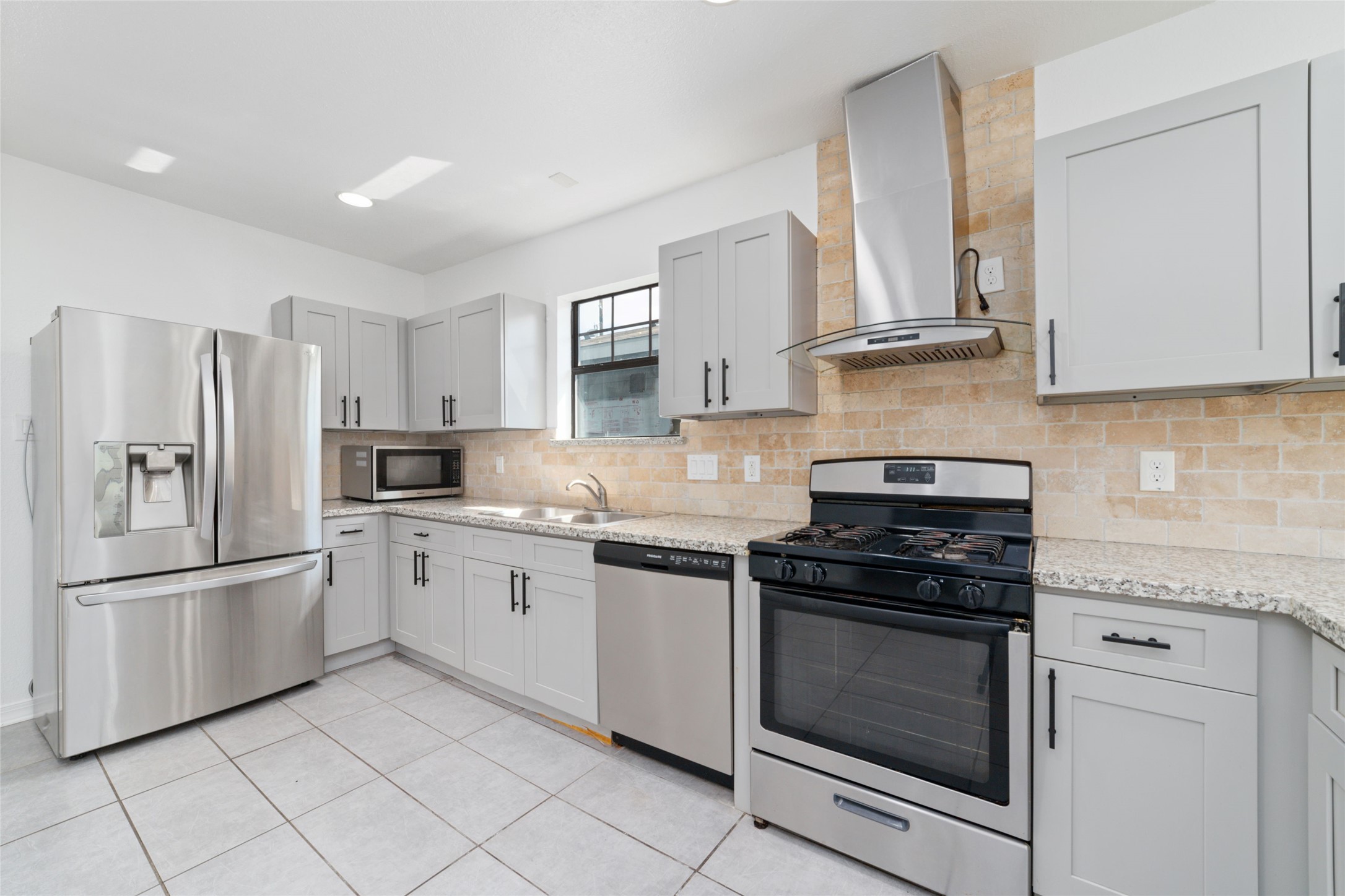 a kitchen with granite countertop white cabinets and stainless steel appliances