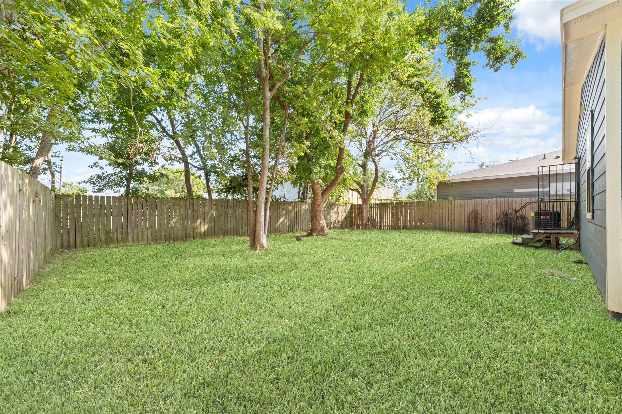 433 Calloway Street Houston, TX 77029 - Photo 25 of 29 a view of a backyard with large trees and wooden fence
