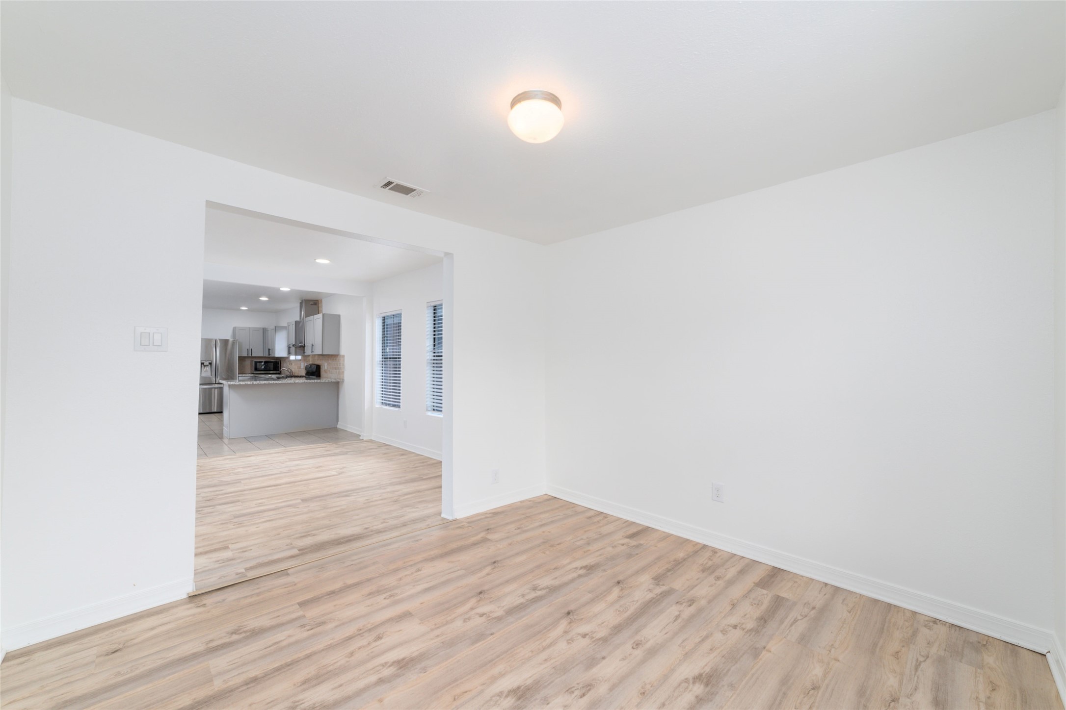 433 Calloway Street Houston, TX 77029 - Photo 6 of 29 a view of an empty room and kitchen view with wooden floor