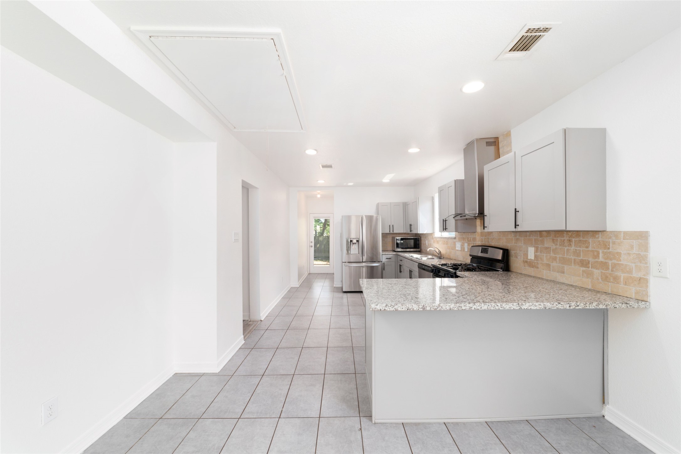 433 Calloway Street Houston, TX 77029 - Photo 10 of 29 a large kitchen with kitchen island a island a sink a counter top space and cabinets