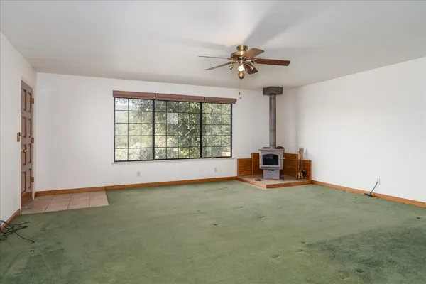 a view of a livingroom with a fan and a large window