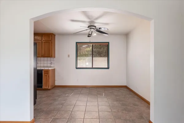 an empty room with windows and fan
