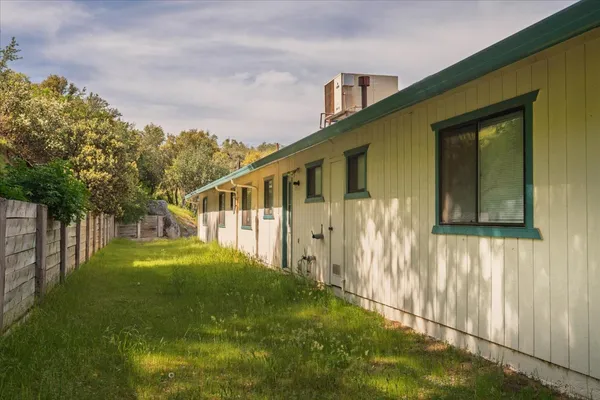 a backyard of a house with plants and wooden fence