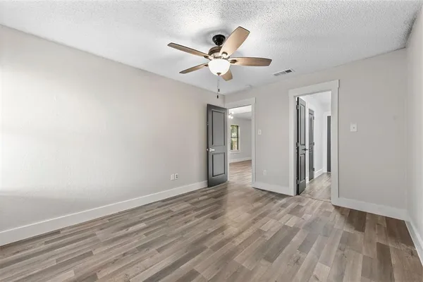 a view of a livingroom with a ceiling fan & hardwood floor