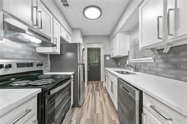 a kitchen with stainless steel appliances granite countertop a stove and a sink