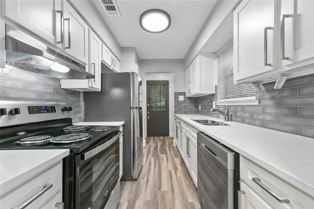 a kitchen with stainless steel appliances granite countertop a stove and a sink