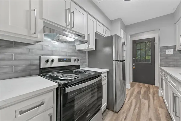 a kitchen with stainless steel appliances granite countertop a stove and a refrigerator