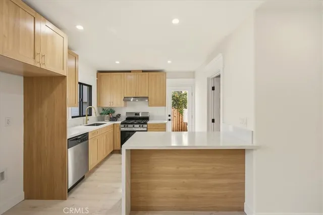 a large kitchen with kitchen island a sink stainless steel appliances and cabinets