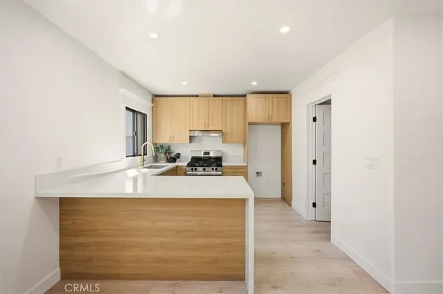 a room with kitchen island a sink dishwasher stove and refrigerator